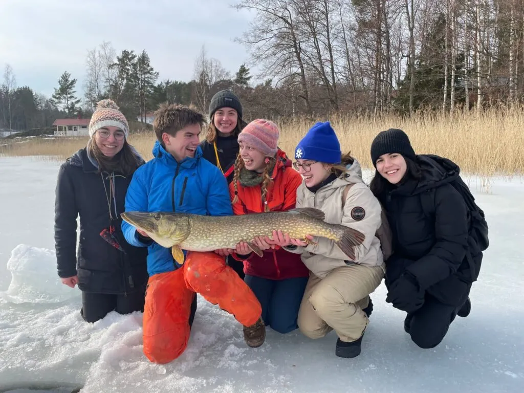 A group photo of people who have caught a long fish